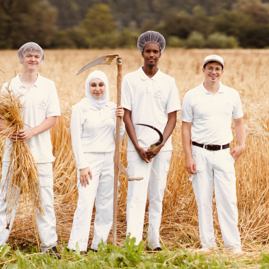 Bei der Getreideernte: v.l. die Bäckerlehrlinge Mario, Amira und Mahamed mit ihrem Ausbildner Daniel Klotz.